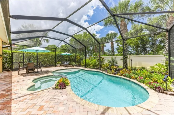 View of pool with an in ground hot tub, a lanai, and a patio area