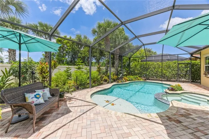 View of pool with a patio and glass enclosure