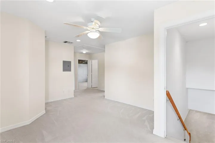 Spacious carpeted room featuring a ceiling fan with integrated lighting, recessed ceiling lights, and light-toned walls