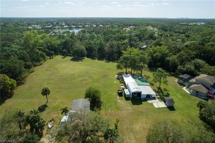 Expansive green spaces featuring mature trees and a detached structure with a metal roof