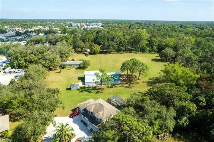 Expansive property featuring lush green lawns and abundant mature trees