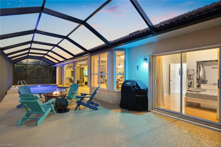 View of patio / terrace featuring a lanai, a sunroom, a fire pit, and a grill