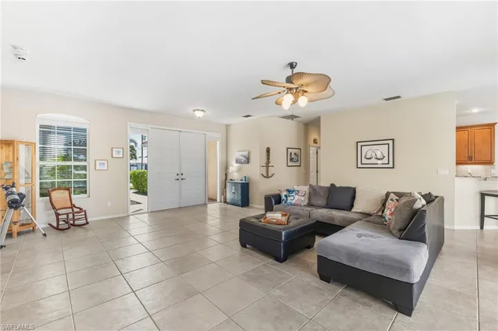 Living room featuring light tile patterned flooring and ceiling fan