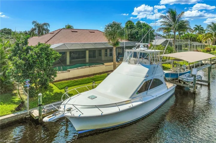 Dock featuring glass enclosure, boat lift, and a water view