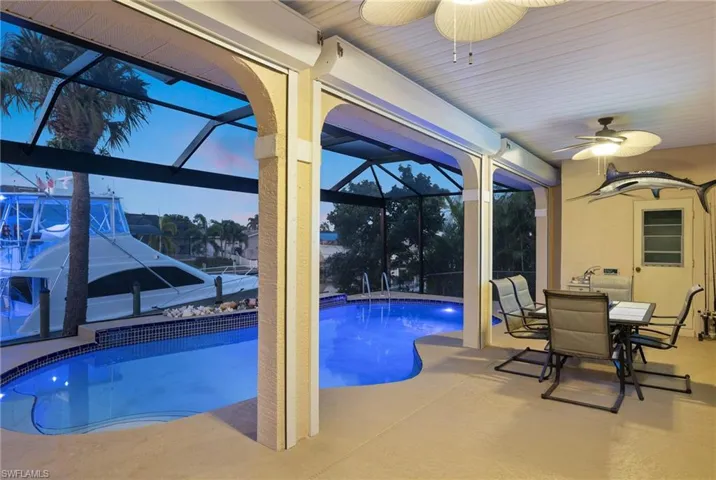Swimming pool featuring a ceiling fan, a lanai, a sunroom, and a patio