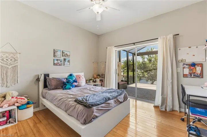 Bedroom with light wood finished floors, access to outside, and a ceiling fan