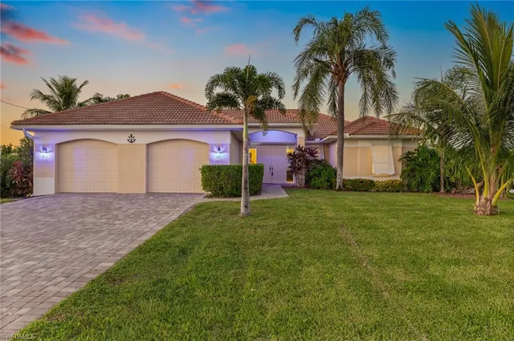 Mediterranean / spanish home with stucco siding, a front yard, decorative driveway, an attached garage, and a tile roof