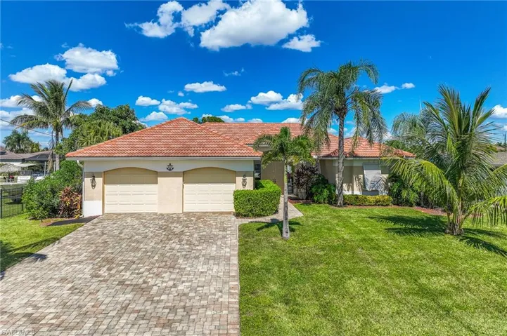 Mediterranean / spanish house with stucco siding, a front yard, decorative driveway, a tile roof, and an attached garage