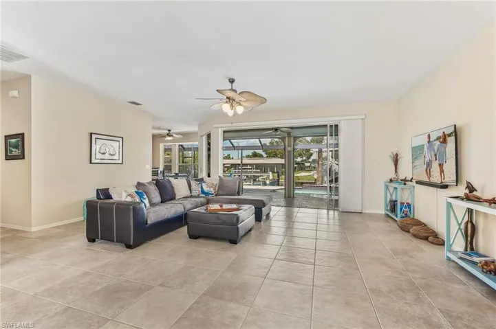 Living area with light tile patterned flooring and a sunroom