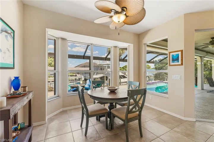 Dining area with ceiling fan, a sunroom, and light tile patterned floors