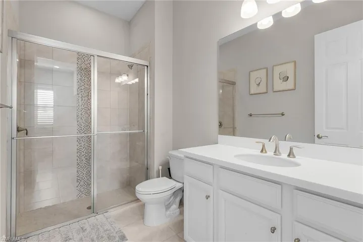 Bathroom featuring vanity, a stall shower, and light tile patterned flooring