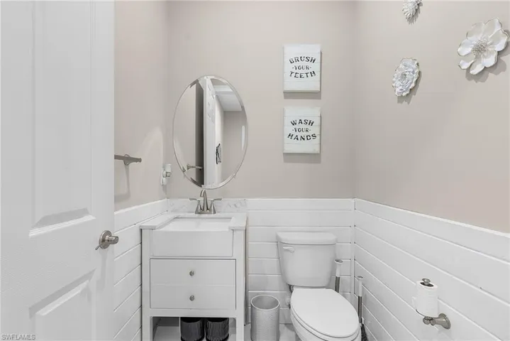 Downstairs half bathroom with wainscoting and vanity