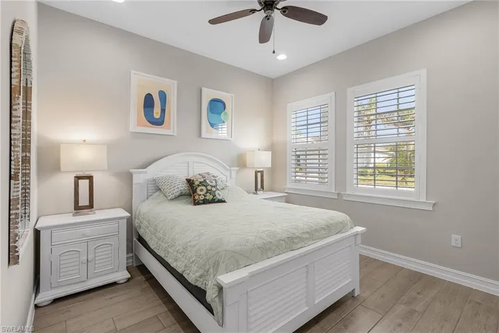 Bedroom featuring light wood-style floors, a ceiling fan, and recessed lighting
