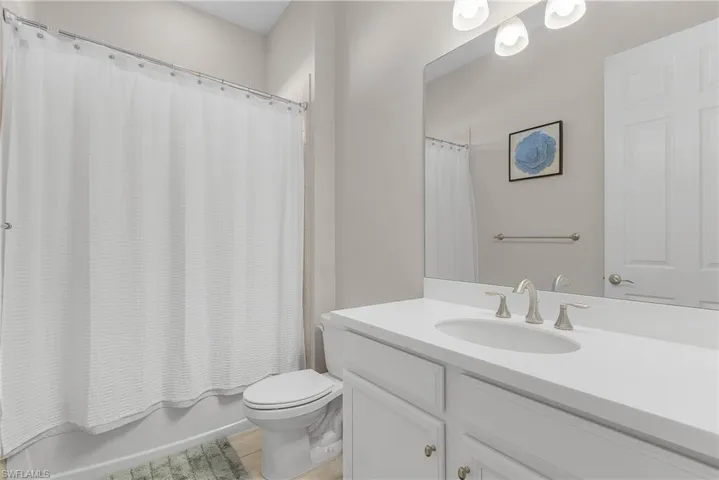 Full bathroom featuring shower / bath combination with curtain and vanity