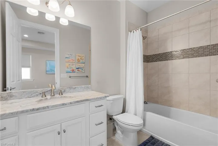 Upstairs Full bathroom featuring shower / bath combination with curtain, vanity, and light tile patterned floors