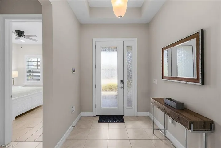 Foyer entrance with light tile patterned floors and a ceiling fan