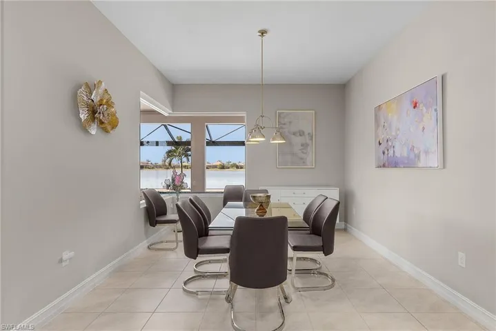 Dining room with light tile patterned floors and a water view