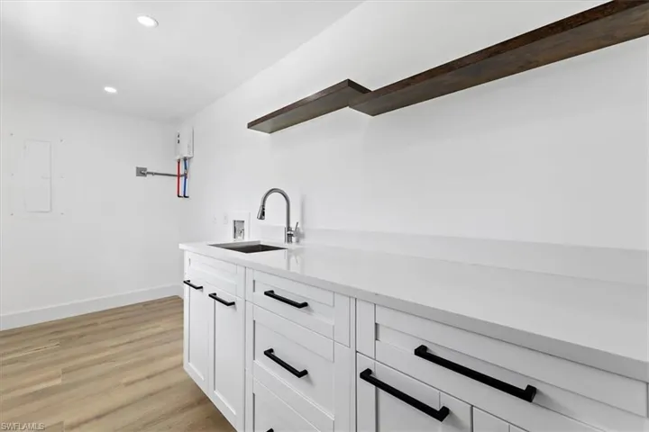 Kitchen featuring light hardwood / wood-style flooring, sink, and white cabinetry