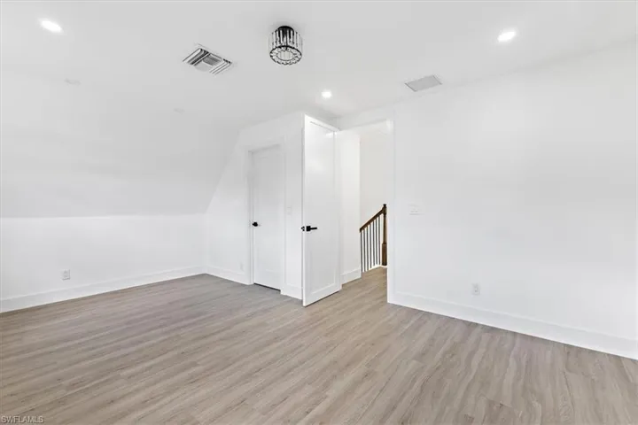 Additional living space featuring lofted ceiling and light hardwood / wood-style floors