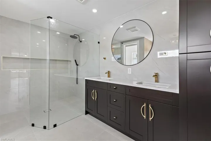 Bathroom featuring tile patterned floors, vanity, tasteful backsplash, tiled shower, and tile walls