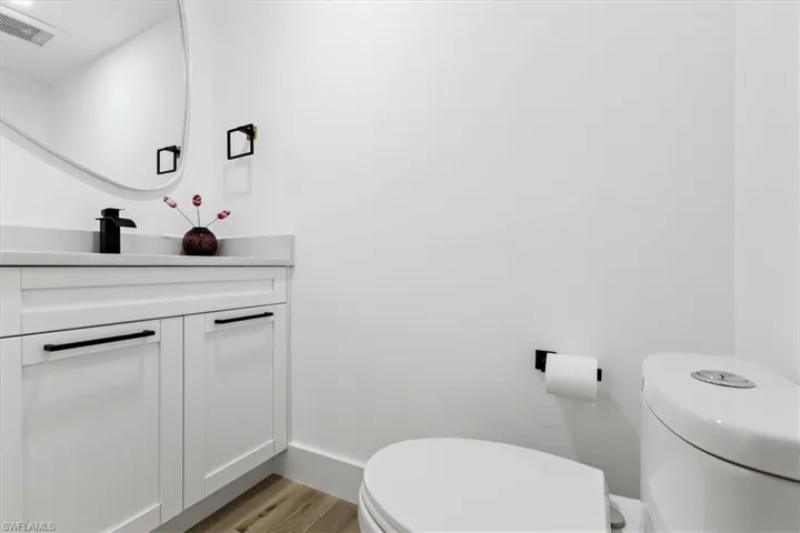 Bathroom with vanity, toilet, and hardwood / wood-style flooring