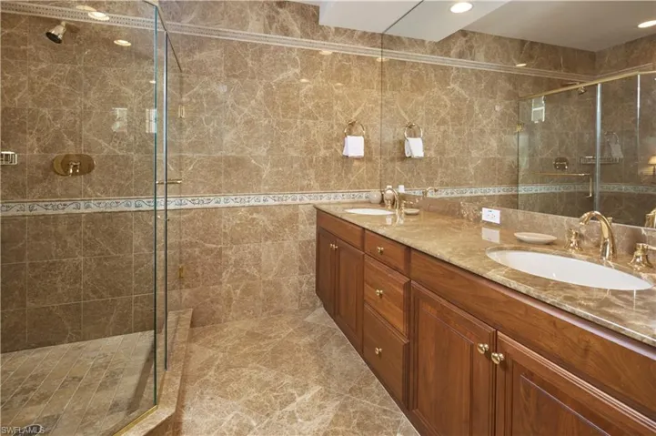 En suite guest bathroom with dual sinks and walk in shower.
