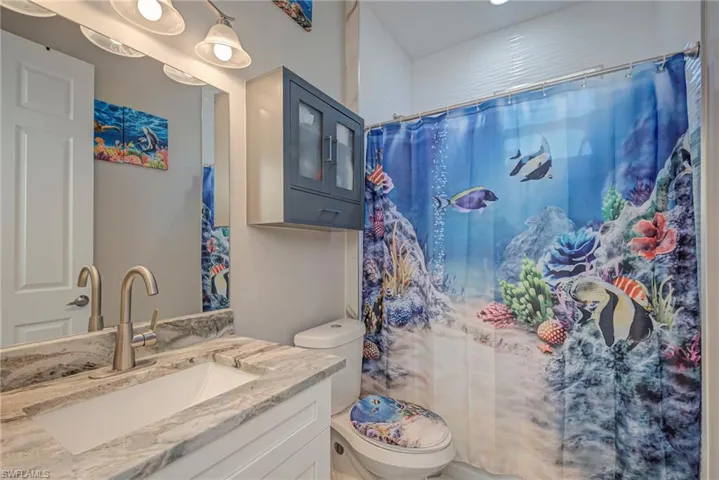 Bathroom with a shower with shower curtain and vanity
