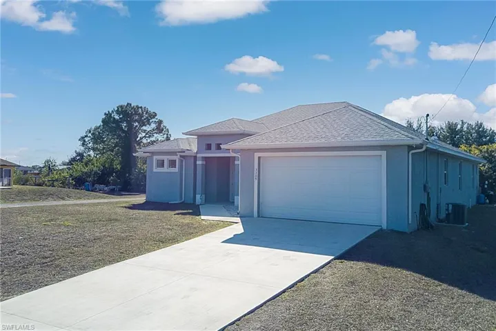 Ranch-style house with stucco siding, concrete driveway, a garage, and roof with shingles