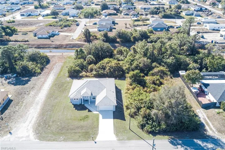 Aerial view of property and surrounding area with nearby suburban area