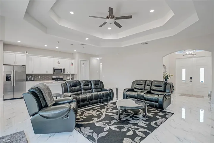 Living area featuring recessed lighting, a ceiling fan, and arched walkways
