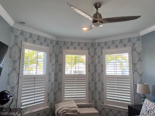 Living area featuring crown molding and a ceiling fan