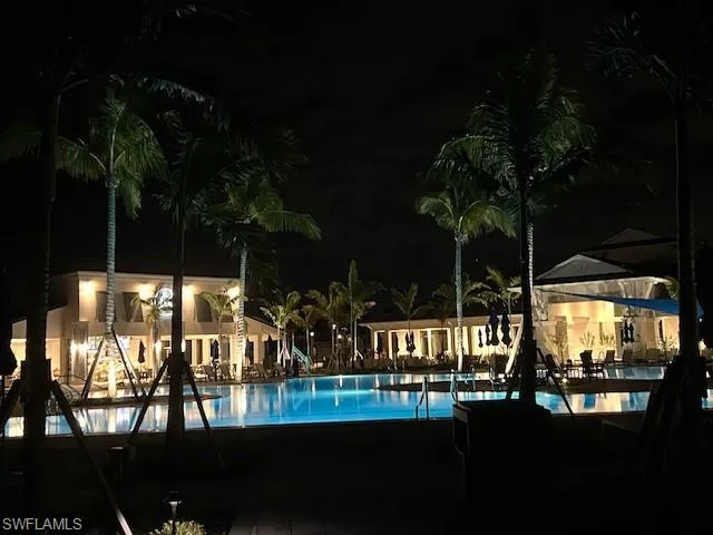 Pool at twilight featuring a community pool and a patio