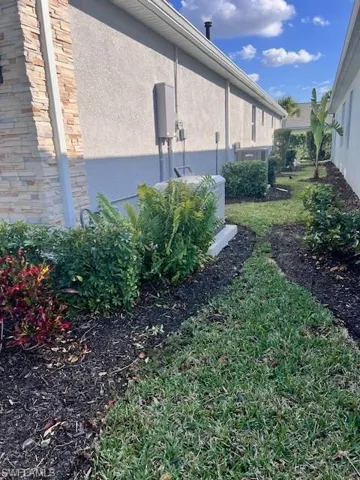 View of property exterior with stucco siding and a yard