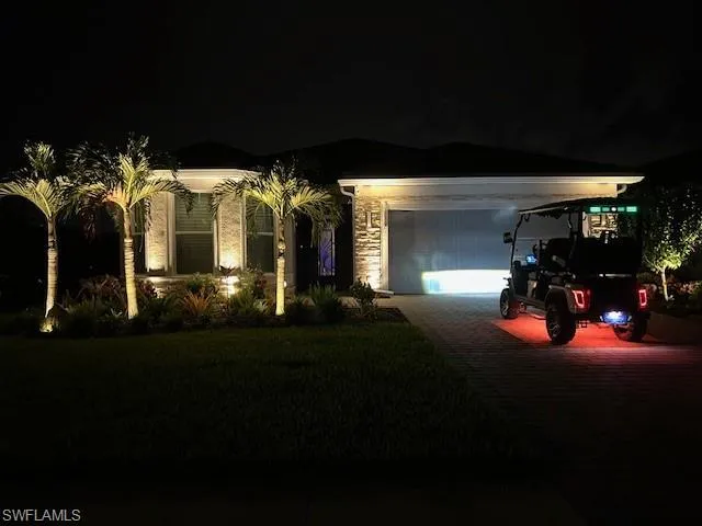 View of front of home with driveway, an attached garage, and a yard