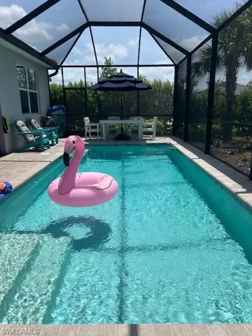 Swimming pool with a lanai, a sunroom, and grilling area