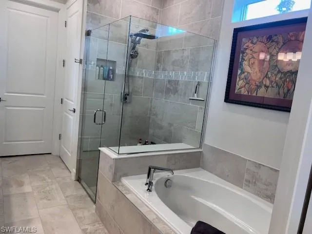 Bathroom featuring a shower stall and a bath