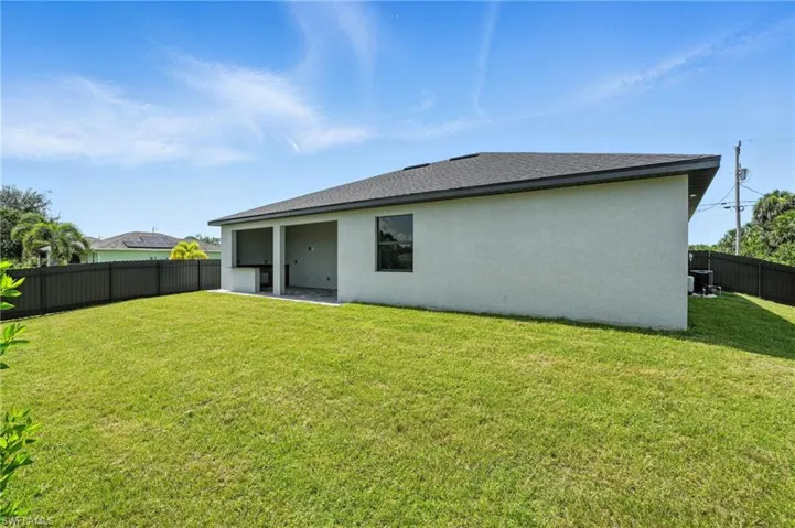 Rear view of property featuring stucco siding and a fenced backyard
