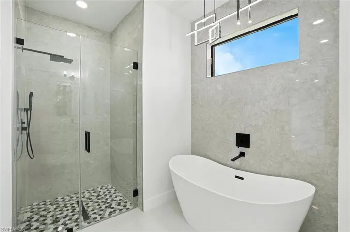 Full bathroom with a freestanding bath, a shower stall, and tile patterned flooring