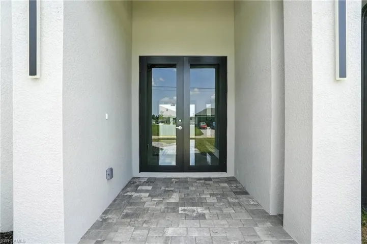 Entrance to property featuring french doors and stucco siding