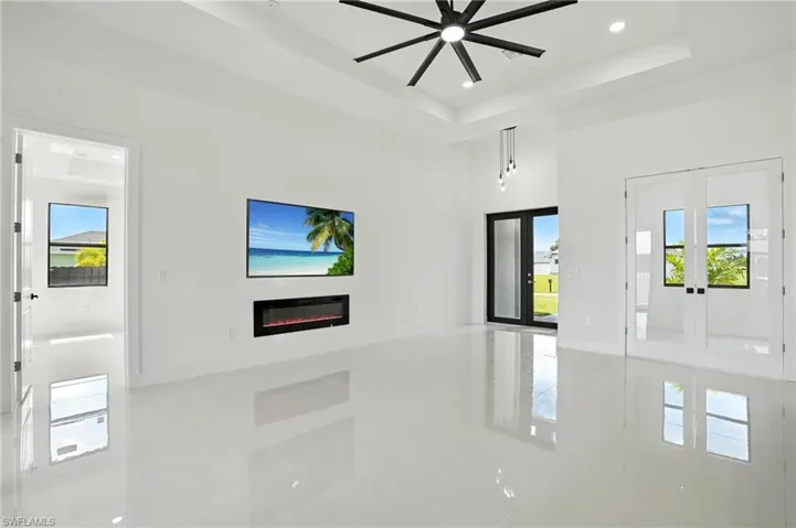 Unfurnished living room with tile patterned floors, a glass covered fireplace, plenty of natural light, a ceiling fan, and recessed lighting