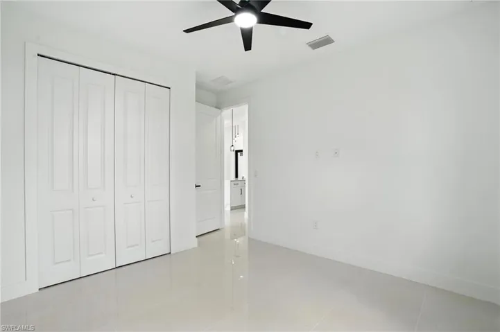 Unfurnished bedroom featuring a closet, ceiling fan, and light tile patterned flooring