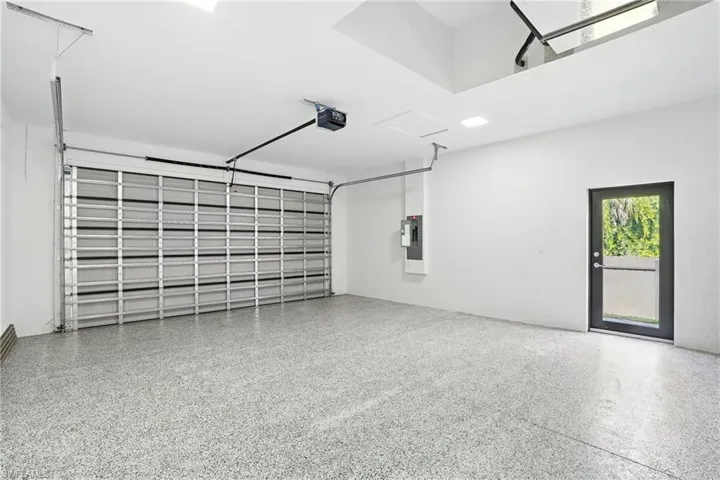 Garage featuring a garage door opener and electric panel