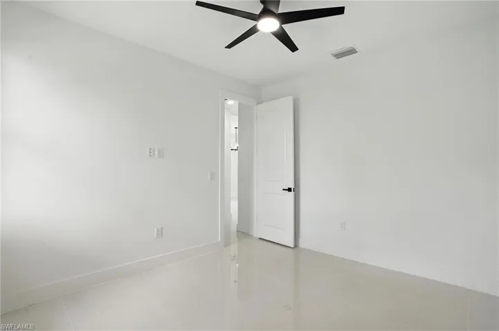 Spare room featuring a ceiling fan and light tile patterned floors