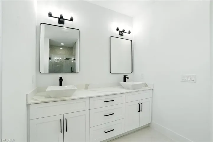 Full bathroom with double vanity and a stall shower
