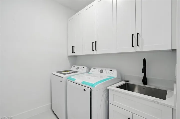 Laundry area with washer and clothes dryer and cabinet space
