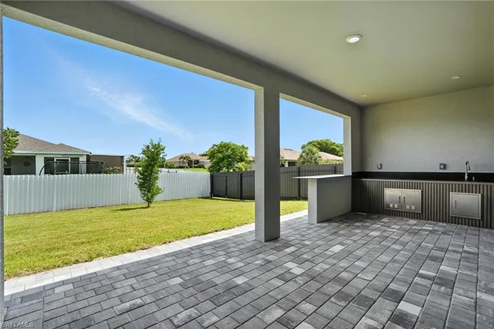 Fenced backyard featuring a patio and a sink
