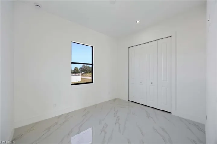 Unfurnished bedroom with a closet, recessed lighting, and light marble finish flooring