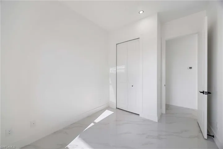 Unfurnished bedroom featuring recessed lighting, a closet, and light marble finish floors