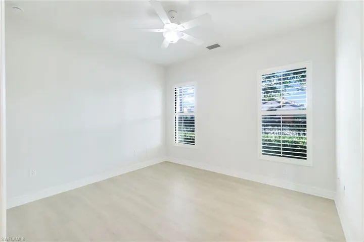 Empty room with light wood-style floors and ceiling fan