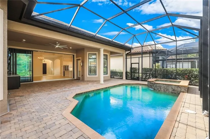 Integrated pool / spa with a patio area, a sunroom, and glass enclosure
